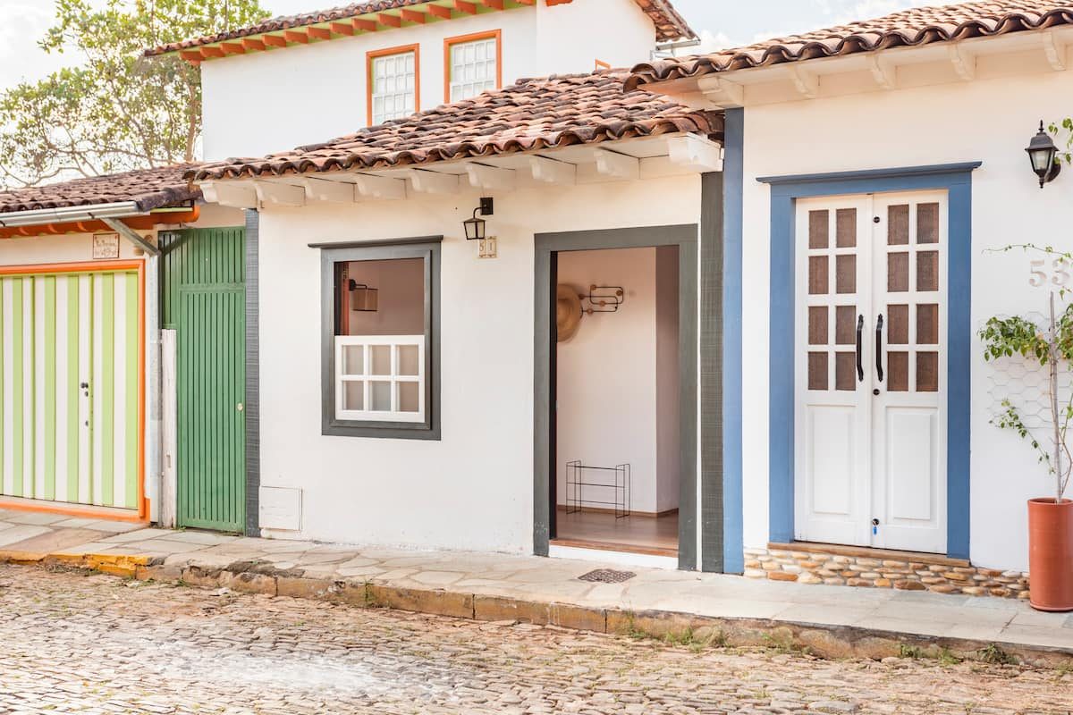 Fachada colonial da Casa Boutique com portas azul e branca, na rua de pedra de Pirenópolis